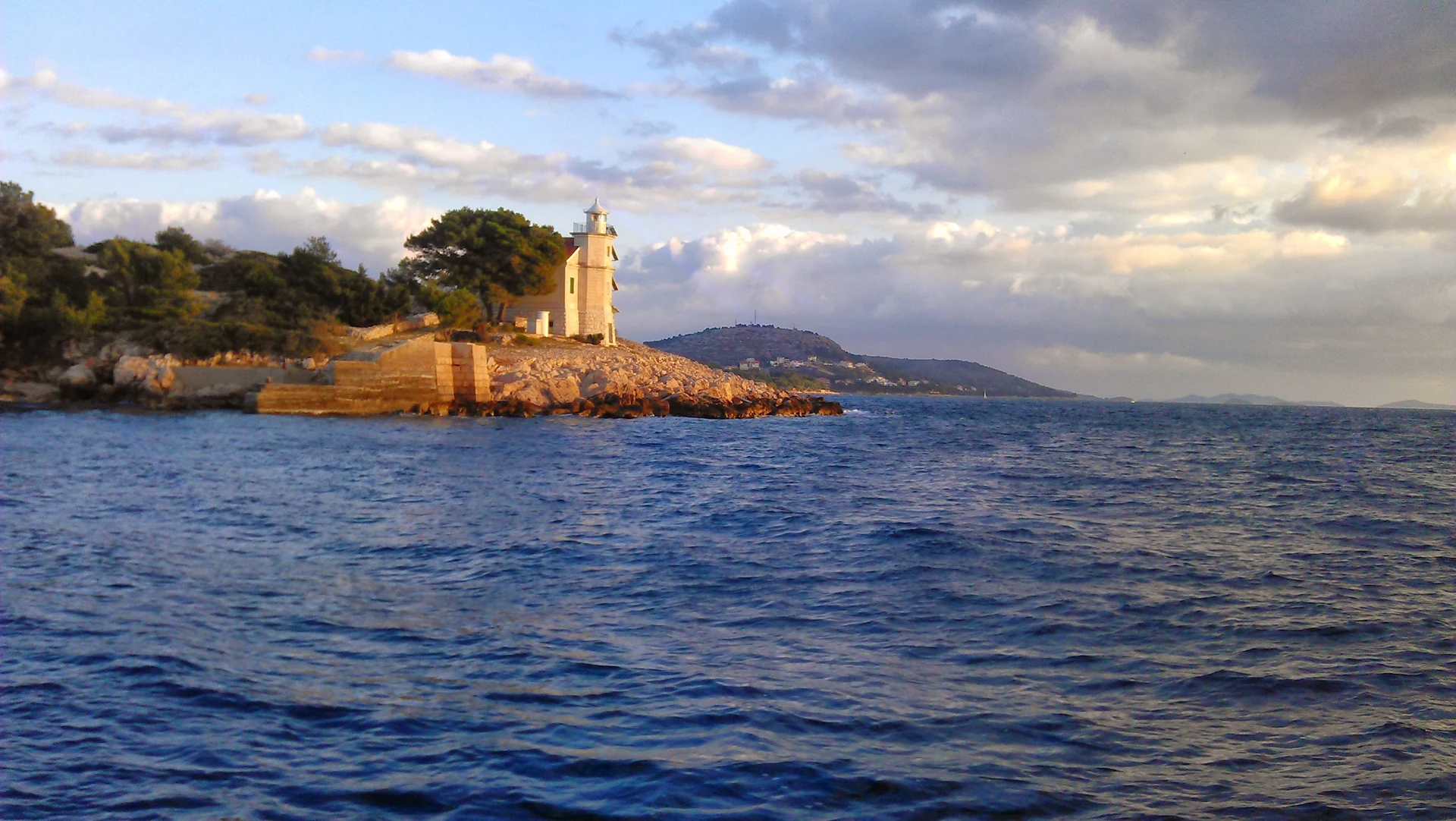 Evening sun on Prišnjak lighthouse and its stone landing steps